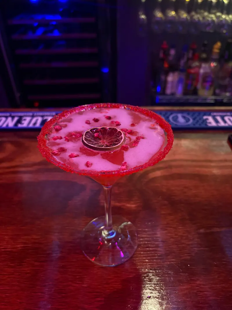 A red cocktail with a citrus garnish on the Intertwine bar